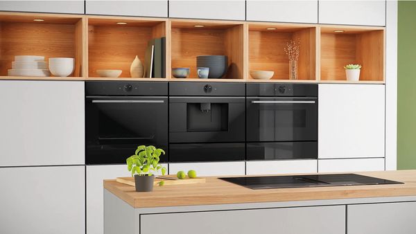 Attractive Bosch oven, espresso machine and microwave integrated into a wall.
