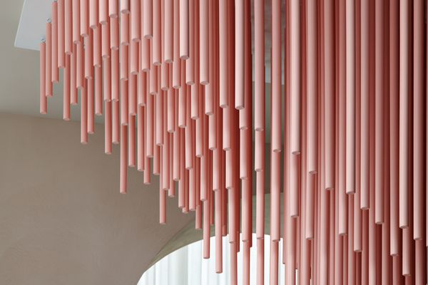 Close-up of a pale pink, flamingo-esque light installation in the new Miami Flagship showroom