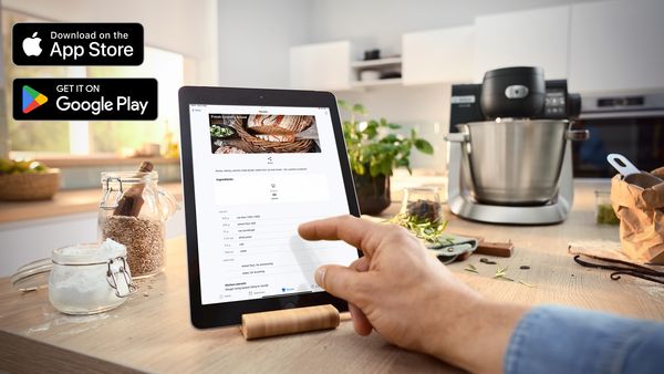 Tablet placeret på køkkenbord med opskrifter.