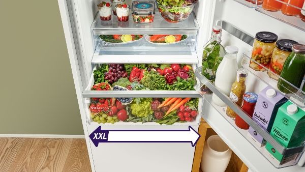Fridge door open showing fresh food in large storage drawer