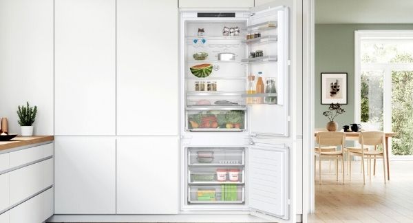 Built in fridge freezer with doors open showing interior