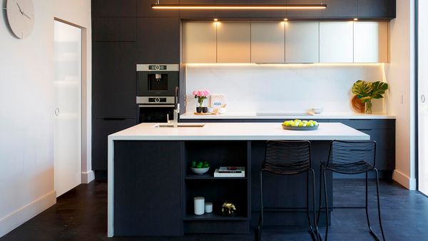 A very elegant black kitchen with a microwave-oven tower