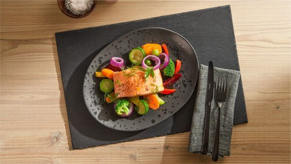 Cooked salmon on a plate in a white kitchen.