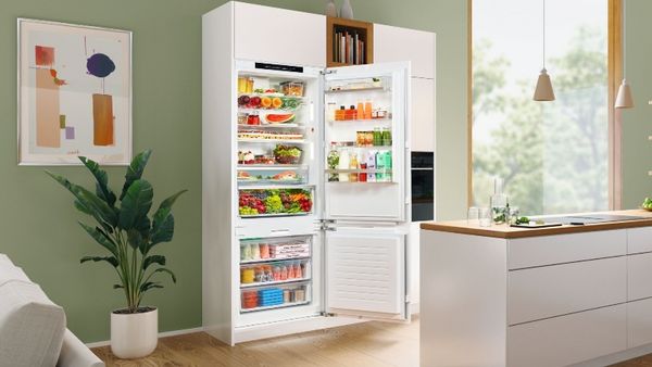 Built in fridge freezer with doors open showing inside contents