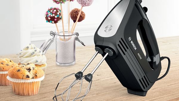 ErgoMixx hand mixer with a mixing bowl and stand next to a quiche.