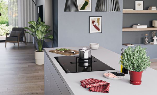 Perspective angulaire d'un îlot de cuisine équipé d'une table de cuisson Bosch avec module de ventilation intégré. 