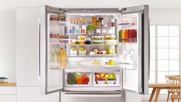 Double door fridge with both doors open showing food inside