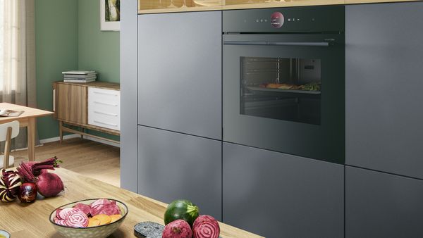 En indbygningsovn i Serie 8 accent line fra Bosch med Air Fry funktion og varmeskuffe. Grøntsager tilberedes i ovnen.