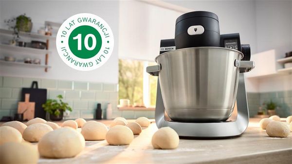 Obraz pokazujący robota kuchennego typu planetarnego Serie 6 na blacie kuchennym obok szeregu misek z ciastem, z nałożonym logo 10-letniej gwarancji.