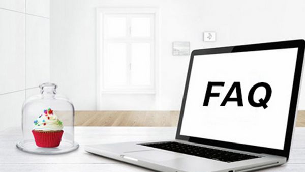 FAQ på bärbar dator hjälper till att besvara dina frågor, medan en läcker tårta står bredvid.