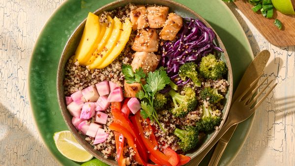 Un castron colorat cu seminţe de quinoa şi mango, varză roşie, broccoli, ardei gras, ridichi şi carne de pui.