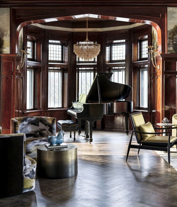 A piano in a wood paneled entertainment area.