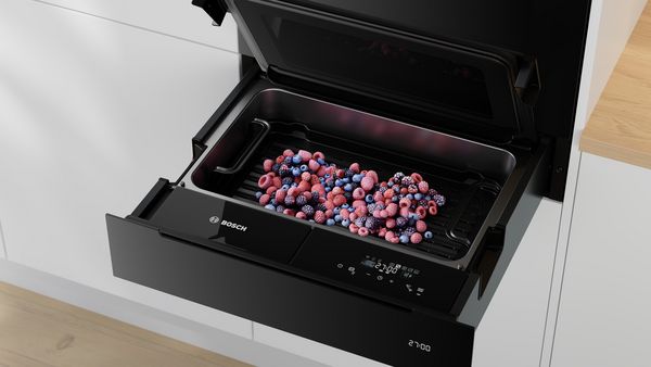 Un aparat Bosch cu un sertar plin cu fructe de pădure asortate congelate.