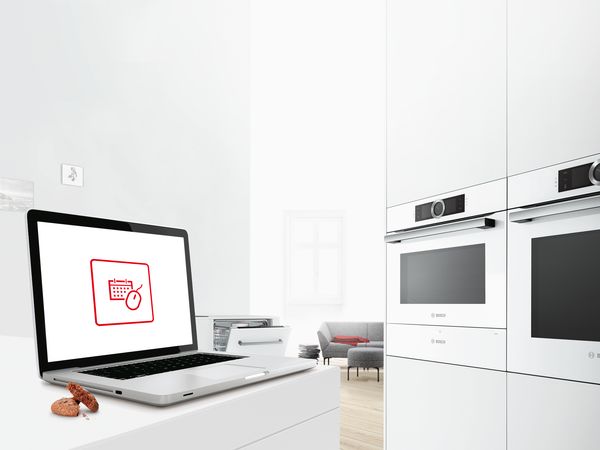 Táblagép egy konyhaszigeten, a kijelzőjén egy olyan ikonnal, amely a Bosch online foglalórendszert jelképezi. 