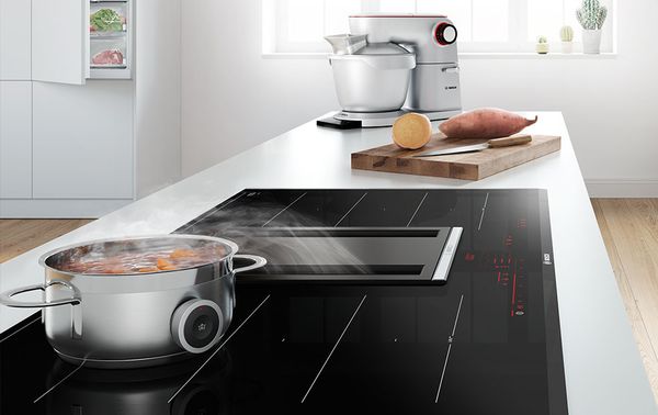 Bosch hob with downdraft ventilation and cooking sensor steaming on hob
