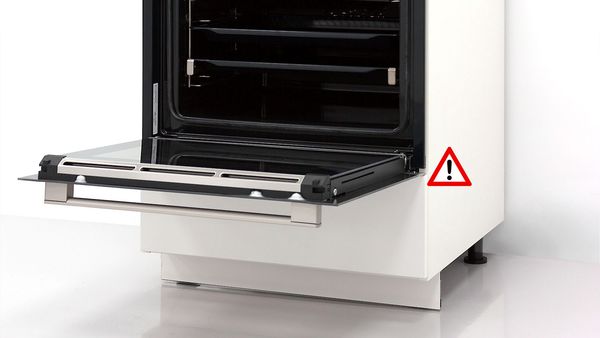 Bosch-uuni luukku täysin avoinna valkoisessa keittiönkaapissa. Punainen varoitusmerkki.