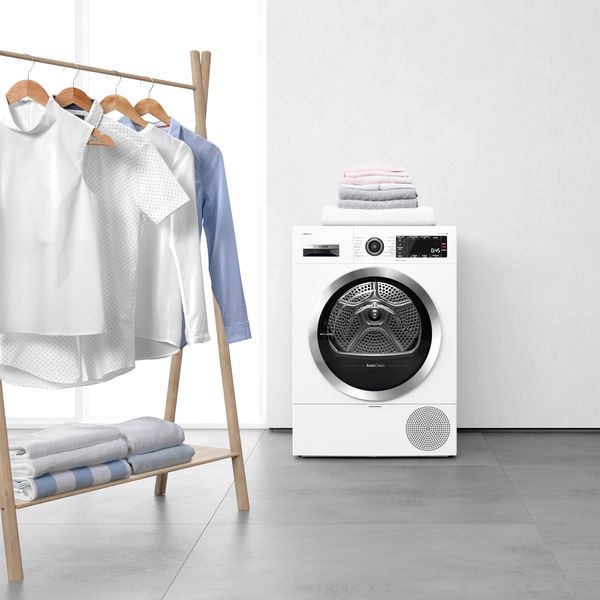 Row of iron shirts next to tumble dryer