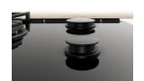 Une surface en verre à effet miroir illustre la facilité de nettoyage des tables de cuisson Bosch en verre trempé.