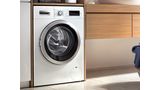 Bosch standard size front load washer in a modern white bathroom