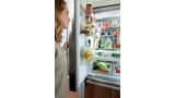Woman opening left door of Bosch refrigerator