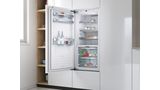 Įmontuojamasis Bosch šaldytuvas atviromis durelėmis, kurio viduje matyti šviežias maistas ir gėrimai.