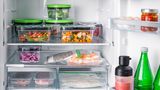 Ein Kühlschrank voller frischer und gekochter Mahlzeiten, vakuumverpackt in Behältern und Frischhaltebeuteln.