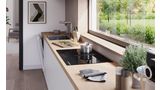 Perspective angulaire d'un aménagement de cuisine sous un fenêtre avec une table de cuisson Bosch avec module de ventilation intégré.