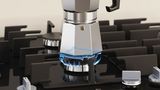 Une machine à espresso est posée sur la plaque de cuisson au gaz.