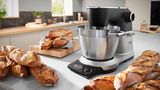 Bosch-Küchenmaschine auf der Arbeitsplatte, umgeben von frisch gebackenen Baguettes in einer modernen Küche.