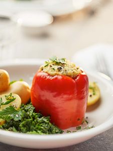 A vegetarian Cookit recipe: red bell peppers stuffed with bulgur wheat. Served with spinach, parsley and potatoes. 