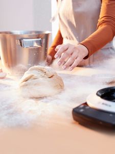 Pétrissage de la pâte à pain sur un plan de travail fariné.