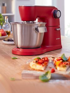 Rote Bosch Küchenmaschine mit großer Rührschüssel aus Edelstahl.