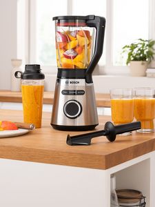 VitaPower Series 4 blender filled with yellow and orange fruits placed together with filled glasses and ToGo bottle on kitchen table.