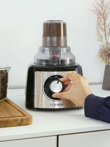 Person moving settings dial to grind coffee