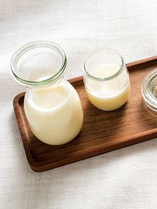 Mleko sojowe stojące na drewnianym stole.
