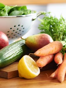 Diferentes frutas e legumes numa bancada de cozinha.