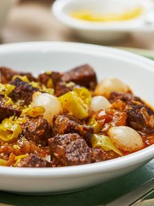 Beef goulash on a plate with onions. 