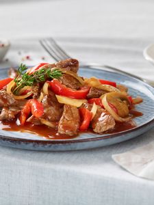 Carne de ternera en rodajas en un plato con pimienta. 