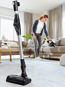 Ultimate bosh cordless vacuum cleaner in front of a woman who is vacuuming the sofa