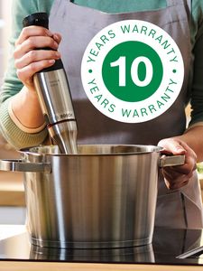 The 10-year warranty logo is superimposed over a shot of someone using an immersion blender in a pot on a hotplate.
