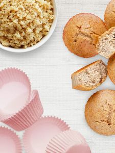 Draufsicht auf eine Schüssel mit gekochter Quinoa und fluffige Muffins. 