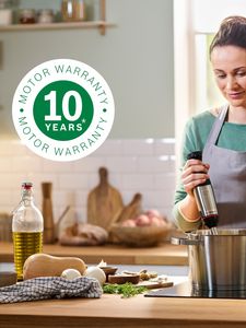 The 10-year warranty logo is superimposed over a shot of someone using an immersion blender in a pot on a hotplate.