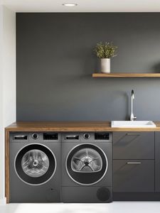 Stacked Bosch dryer and washer with a convenient pull-out shelf for laundry.