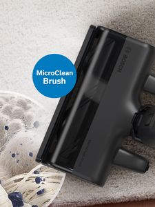 La brosse MicroClean sur un tapis et une loupe grossissante qui permet de voir les fibres du tapis et les plus petites particules de poussière.