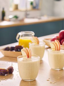 Milchshakes in Gläsern auf der Küchenplatte, garniert mit Fruchtscheiben.