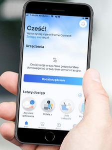 Mężczyzna trzymający telefon, skupiający się na jego wyświetlaczu. Widzimy aplikację Home Connect na ekranie głównym.