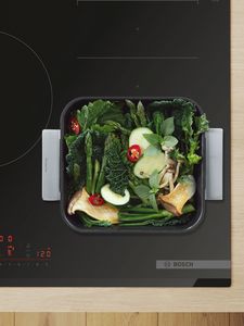 Stainless steel roasting pan with handles, with green veg inside