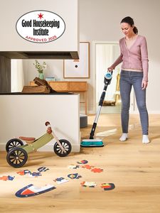 Person using Bosch Aqua vacuum in messy living area, with Good Housekeeping Institute Approved 2025 icon