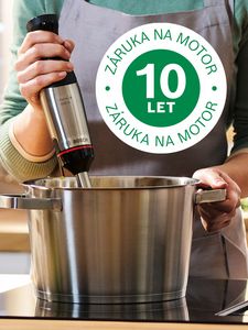 Logo desetileté záruky je překryto záběrem na někoho, kdo používá ponorný mixér v hrnci na varné desce.