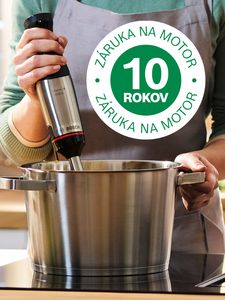 Logo 10-ročnej záruky je umiestnené nad záberom na osobu, ktorá používa ponorný mixér v hrnci na horúcej varnej doske.